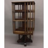 A LARGE LIBRARY SIZE REVOLVING BOOKCASE. The square bookcase with three graduated levels of