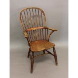 A BEECN AND ELM HIGH BACKED WINDSOR ARM CHAIR. With a raised hoop back, three part arm and shaped