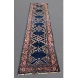 NORTH WEST PERSIAN RUNNER, CIRCA 1920 The indigo field with a column of stepped diamond medallions