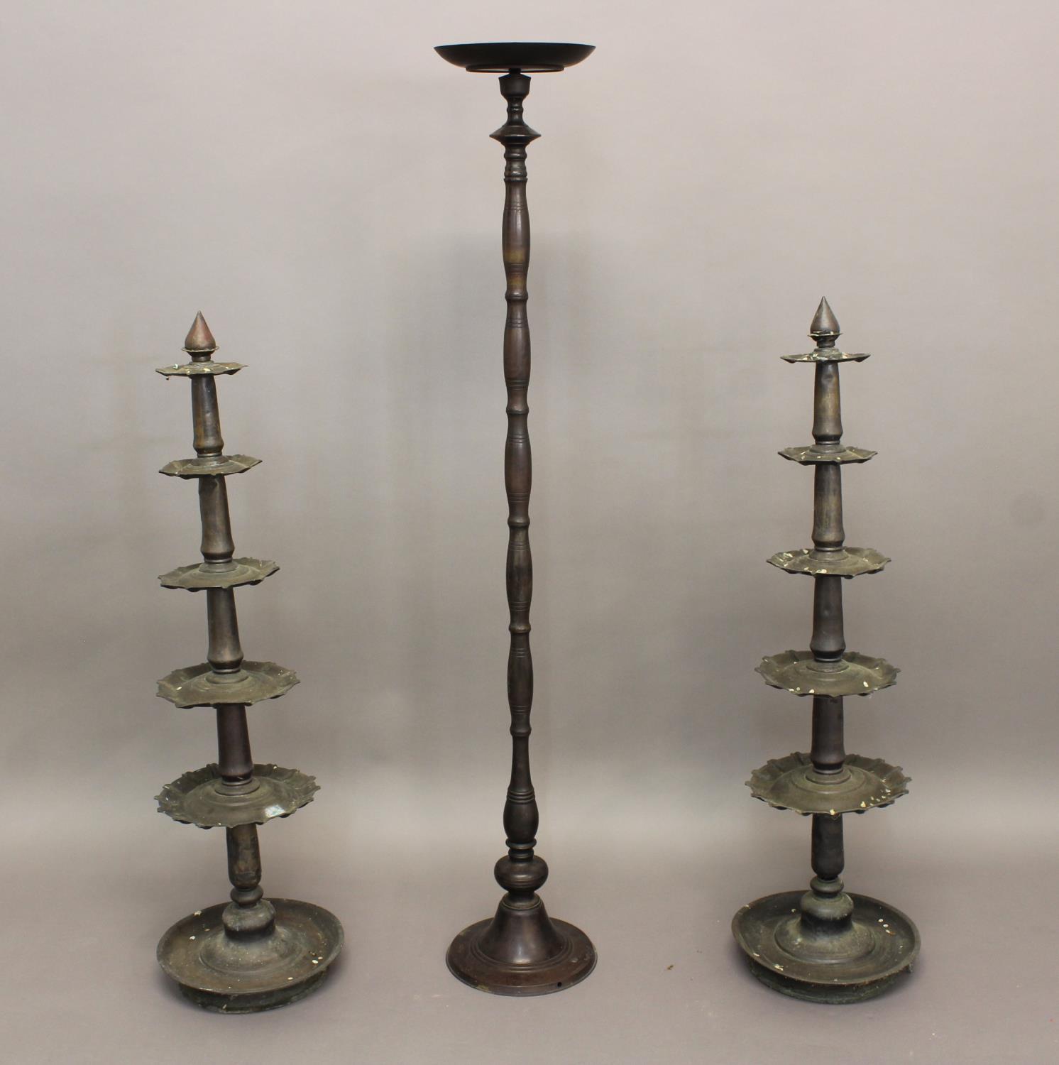 A PAIR OF INDIAN BRASS STANDS each with circular base and five shaped tiers approx. 104 cms high,