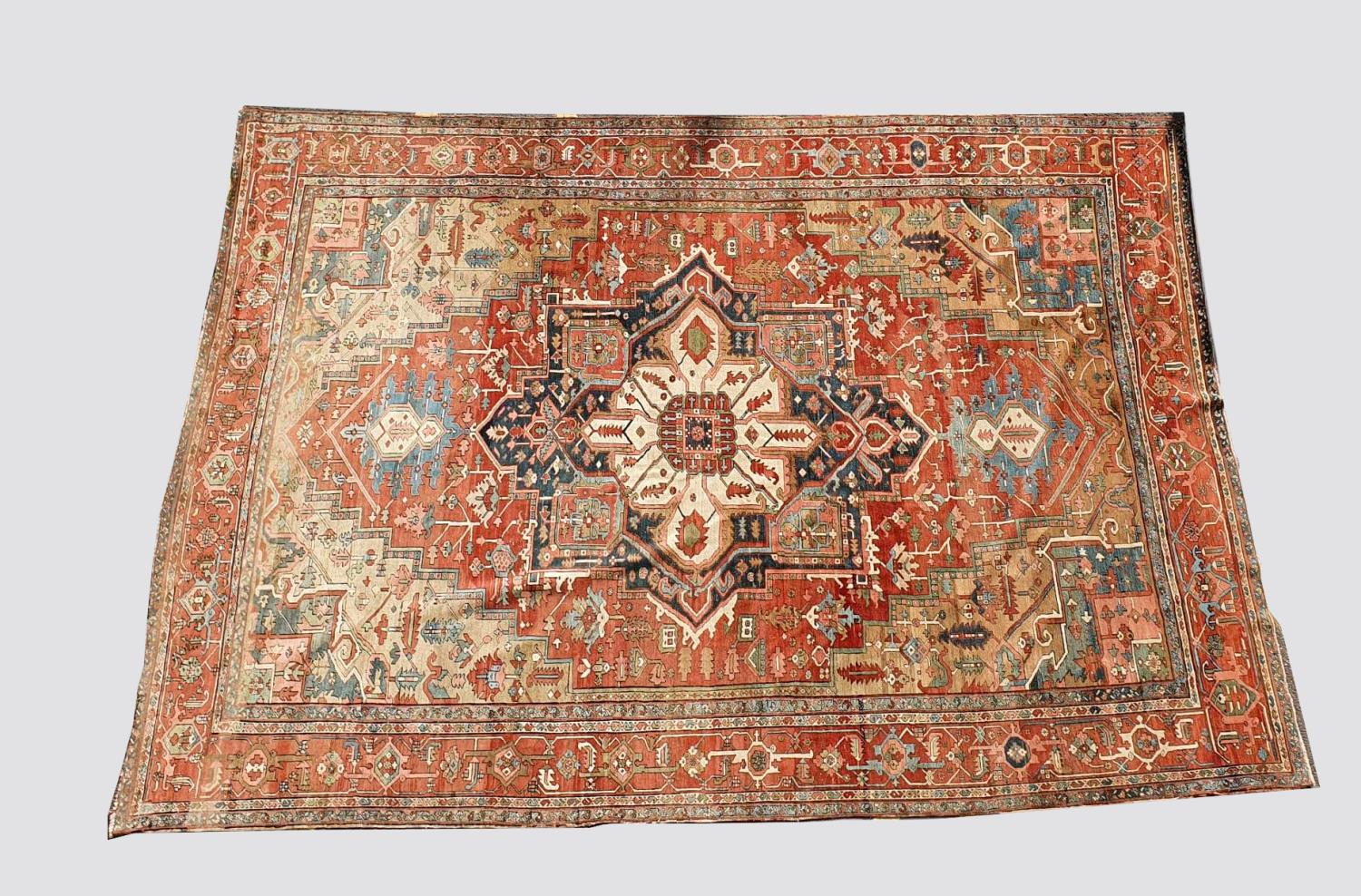 A HERIZ CARPET c1870. Iranian Azerbaijan, The stepped terracotta fields centred by an indigo and