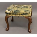 A FOOTSTOOL OF GEORGE I DESIGN with walnut cabriole legs and pointed pad feet, tapestry top; 49 x 42