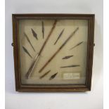 FRAMED ARROW HEADS a cased display with various metal arrow heads and shafts, with an information