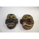 TWO CEYLONESE TRIBAL MASKS two wooden brightly painted tribal masks, both around 23cms high. Also