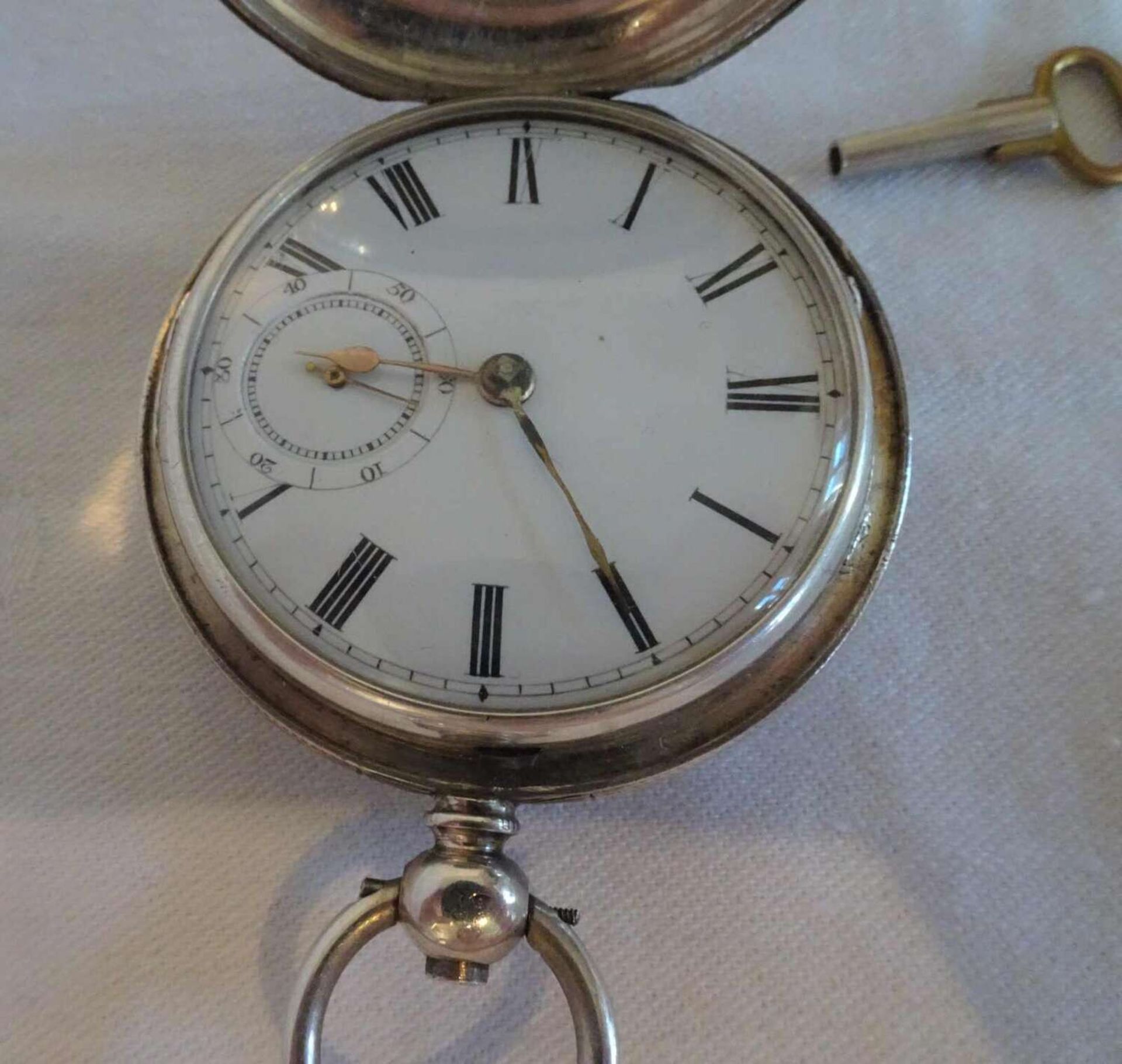 silberne Taschenuhr mit aufklappbarem Gehäuse. Schlüsselaufzug / Schlüssel dabei. Uhr läuft an. - Bild 4 aus 4