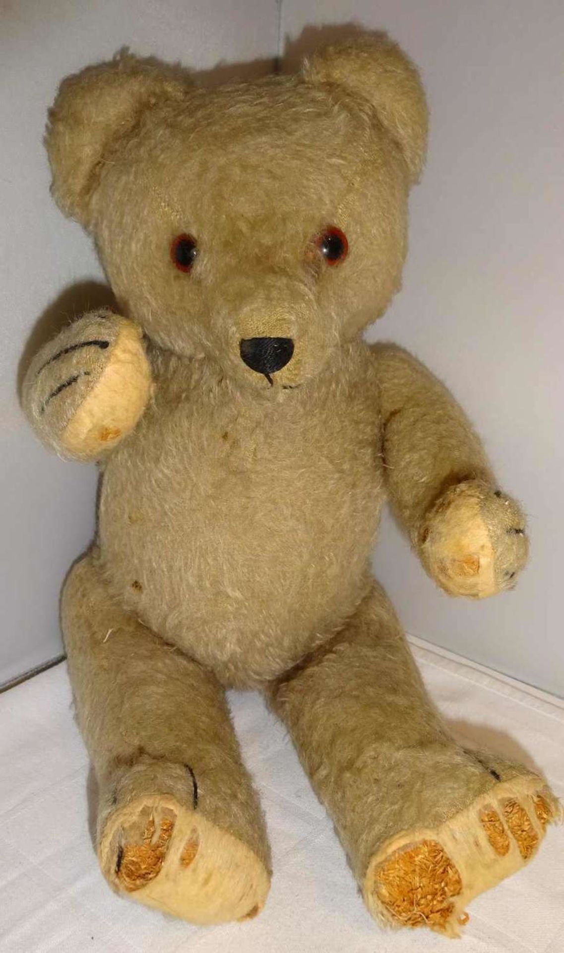 Teddybär, aus alter Holzwolle gestopft. Wohl Steiff mit Glasaugen, teilweise Filzverlust. Schöner