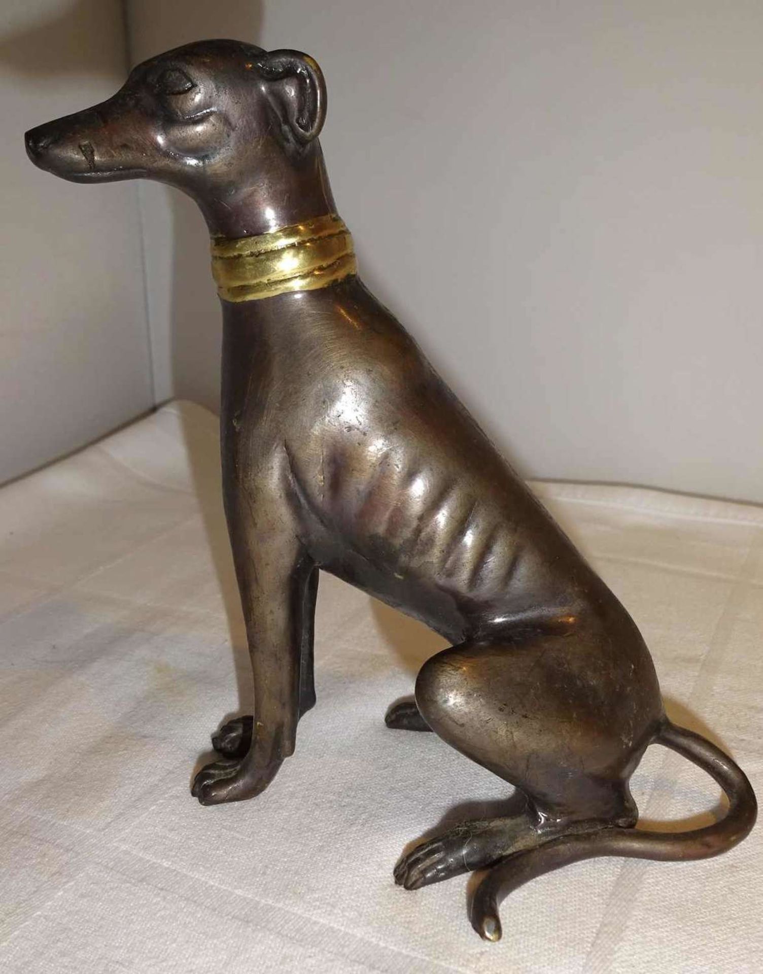 Bronzefigur "Windhund", sitzend, mit goldfarbenen Halsband. Ohne Signatur. Maße: Höhe ca. 13 cm,