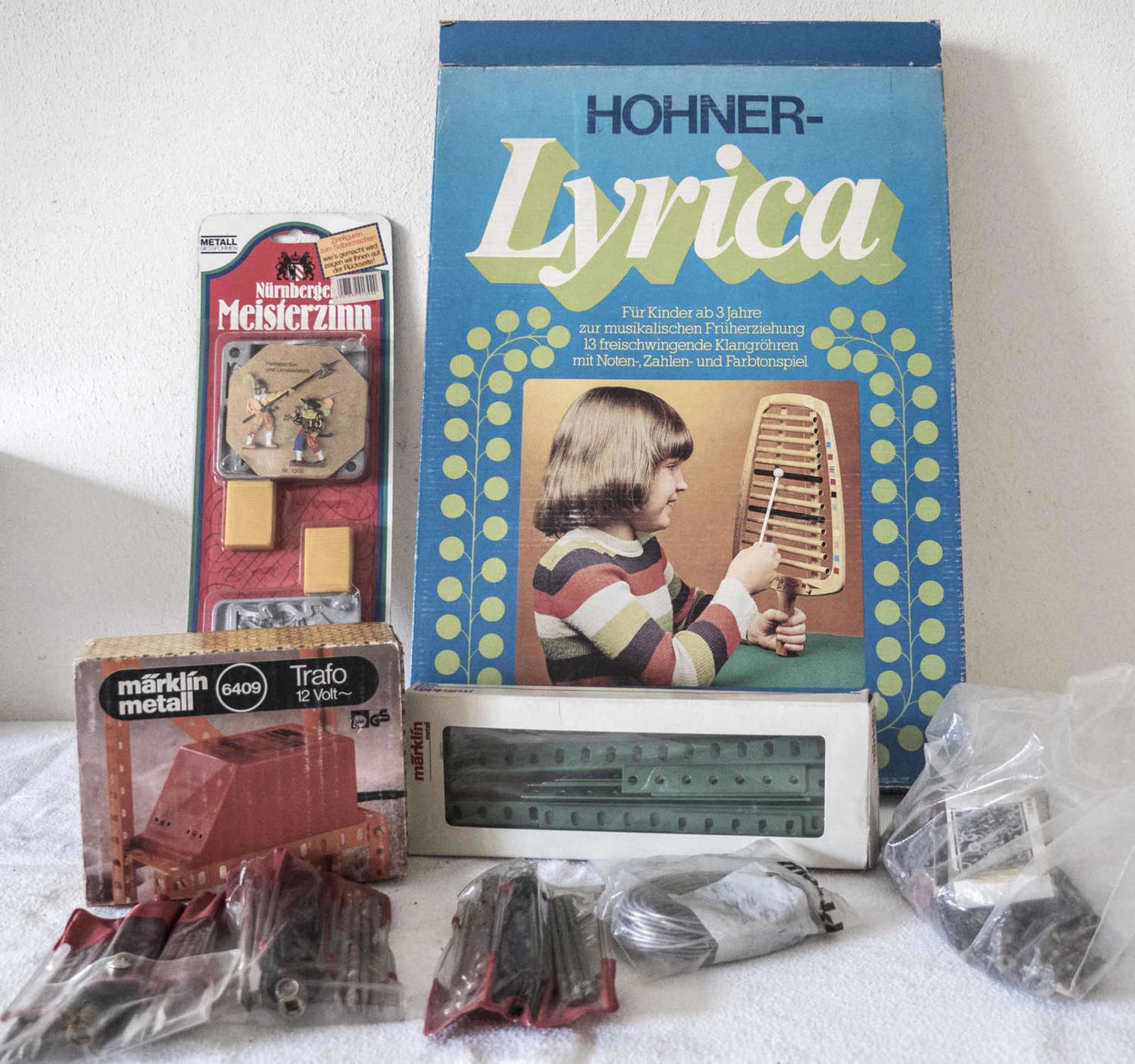 Konvolut Spielzeug, bestehend aus Hohner Lyrica (ohne Klöppel), Nürnberger Meisterzinn, neu in OVP,