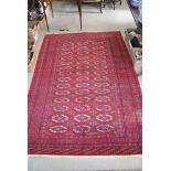 A TEKKE STYLE RUG, 20TH CENTURY, THE MADDER GROUND CENTRED WITH A RECTANGULAR FIELD ENCLOSING