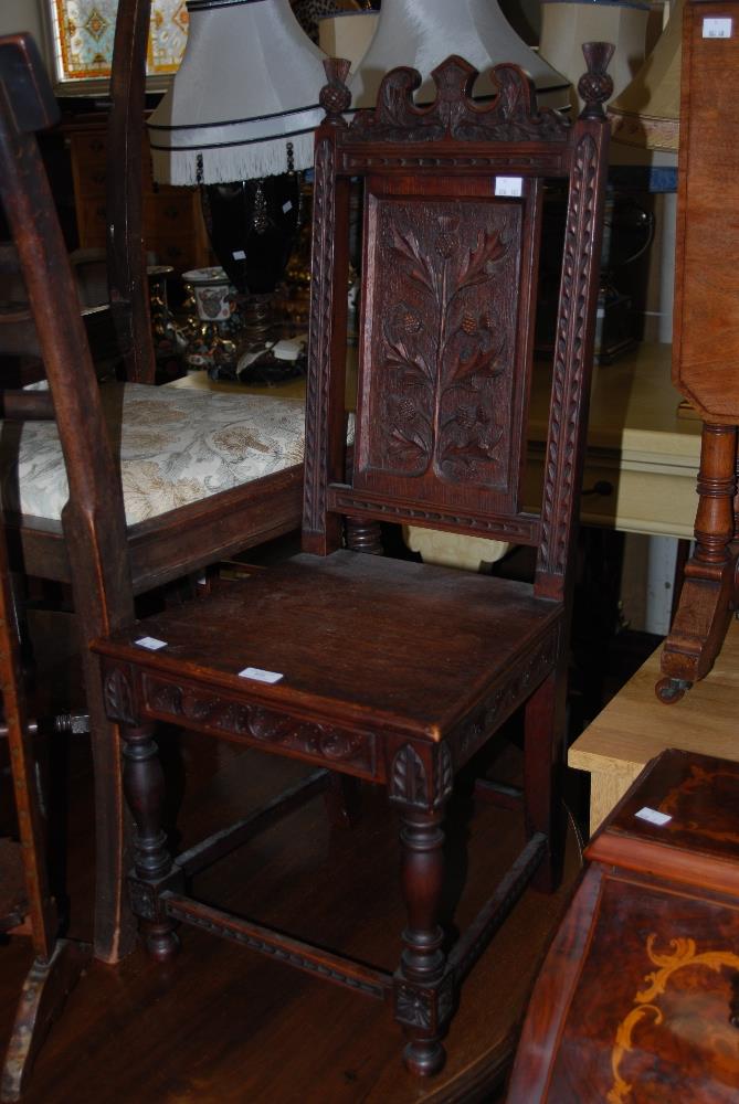 AN EARLY 20TH CENTURY SCOTTISH OAK CHILDS CHAIR WITH THISTLE CARVED PANEL BACK, THISTLE CARVED
