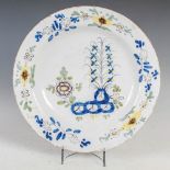 An 18th century Delft charger, decorated with garden of peony in the Fazackerly palette, 35cm