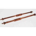 A pair of 19th century mahogany curtain poles and rings, the circular end with faux stud detail,