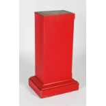 A red painted pine pedestal, 20th century, the rectangular section with chamfered edges to the