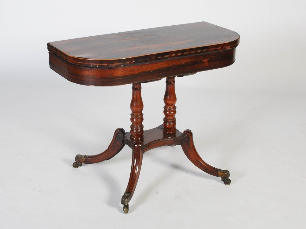 An early 19th century rosewood, boxwood lined and gilt metal pedestal games table, the hinged D-