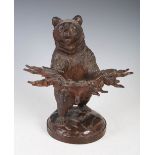 A late 19th/ early 20th century Black Forest carved bear pipe stand, with glass inlaid eyes, 29.