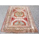 A Persian rug, early 20th century, the russet madder coloured ground centred with an octagonal