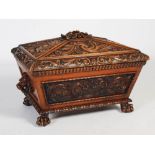 A 19th century oak sarcophagus shaped cellarette, the hinged cover centred with a flower carved