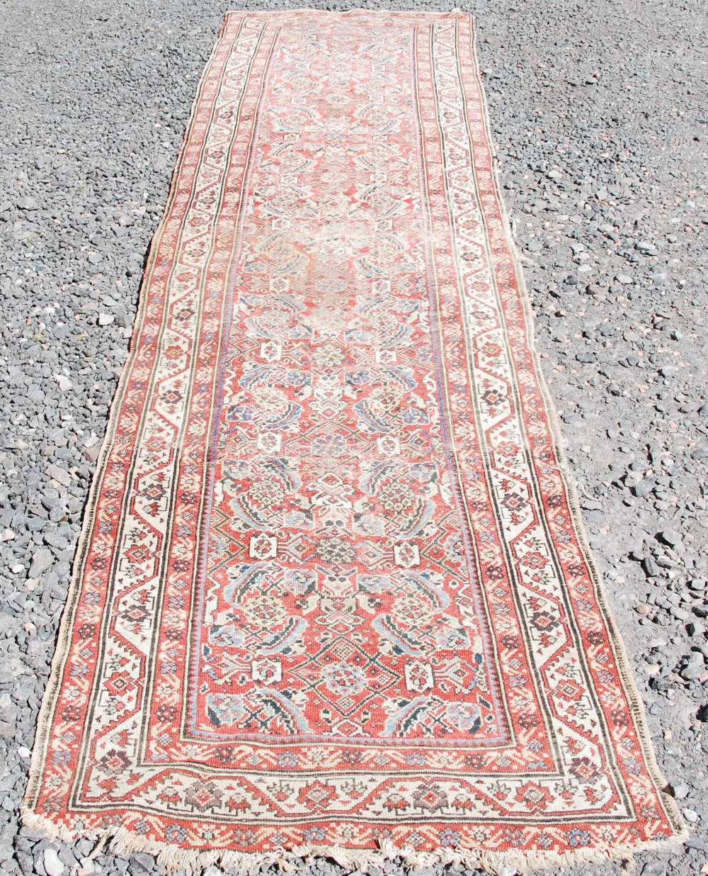 A Persian long rug and a Persian runner, the long rug with a blue rectangular field of stylised