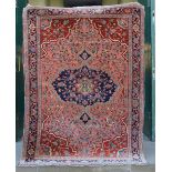 A Persian rug, late 19th/ early 20th century, the salmon pink rectangular field centred with a