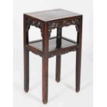 A Chinese dark wood urn stand, Qing Dynasty, the rectangular panelled top above a pierced frieze