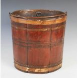 A 19th century mahogany and brass bound oval pail, with hinged carry handle, 34cm high x 34cm wide.