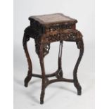 A Chinese dark wood urn stand, Qing Dynasty, the shaped square top with a mottled red and white