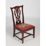 A late 19th/ early 20th century mahogany gossip chair, the shaped top rail above pierced and