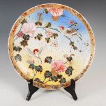 A Japanese Satsuma pottery charger, Meiji Period, decorated in coloured enamels with pair of