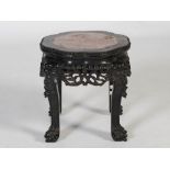 A Chinese dark wood jardiniere stand, Qing Dynasty, the shaped octagonal top with mottled red and