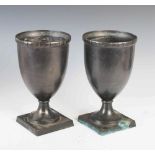 A pair of bronze urns, of tapered cylindrical form on sockel and square plinth bases, 17.5cm