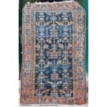 A Persian rug, early 20th century, the blue ground decorated with three rows of stylised flowers