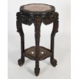 A Chinese dark wood jardiniere stand, Qing Dynasty, the shaped octagonal top with a mottled red