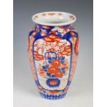 A Japanese Imari vase, late 19th/ early 20th century, decorated with panels of baskets issuing peony