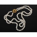 A two row cultured pearl necklet with an 18ct carat gold sapphire and diamond set clasp, circa 1970,