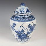 A Japanese Arita blue and white jar and matching cover, Edo Period, the jar decorated with rock-work