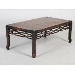 A Chinese dark wood Kang table, Qing Dynasty, the panelled rectangular top above a scroll and ball