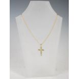 STUART GELNER, A 9ct yellow gold cross pendant, set with six oval faceted peridot, on 9 carat gold