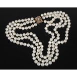 A cultured pearl necklet with 9ct gold and pearl set clasp, triple matinee length rows of forty-