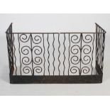 An Arts & Crafts wrought iron nursery fire guard, with two stylised vertical plant forms flanked