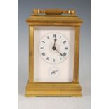 A late 19th century carriage clock with repeater and alarm, the lacquered brass case with a textured