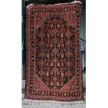 A Persian rug, early 20th century, the blue field decorated with rows of hooked boteh and stylised