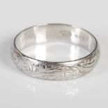 A platinum wedding ring, London, 1979, makers mark of S&W for Slade & Wolfe, with hand engraved