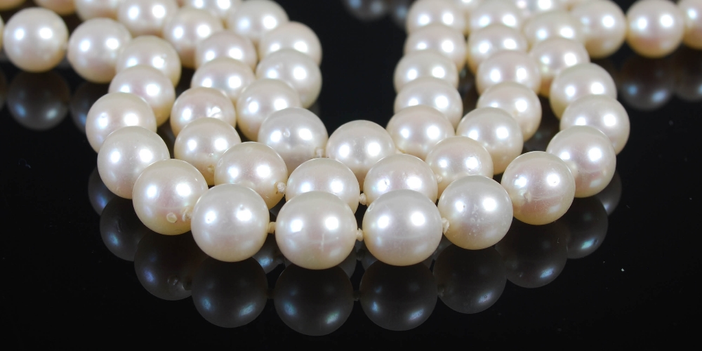 A cultured pearl necklet with 9ct gold and pearl set clasp, triple matinee length rows of forty- - Image 3 of 5