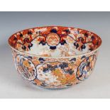 A Japanese Imari bowl, late 19th century, decorated with panels of peony and pine divided by