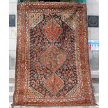 A Persian rug, late 19th/ early 20th century, the rectangular blue ground centred with three lozenge