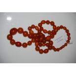 STRING OF GRADUATED AMBER BEADS, GROSS WEIGHT 99.7 GRAMS.