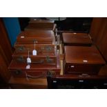 THREE ASSORTED VINTAGE CASES, A BROWN LEATHER GLOVE BOX TOGETHER WITH A MAHOGANY TABLE CASKET AND