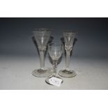 TWO 18TH CENTURY AIR-TWIST WINE GLASSES AND AN 18TH CENTURY CORDIAL GLASS WITH FACETED STEM.