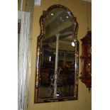 A CHINOISERIE STYLE WALL MIRROR WITH BLACK AND GILT LACQUERED FRAME ENCLOSING BEVELLED MIRROR PLATE