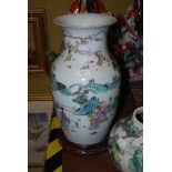 A CHINESE PORCELAIN FAMILLE ROSE VASE DECORATED WITH SCHOLARS AND FIGURES ON HARDWOOD STAND
